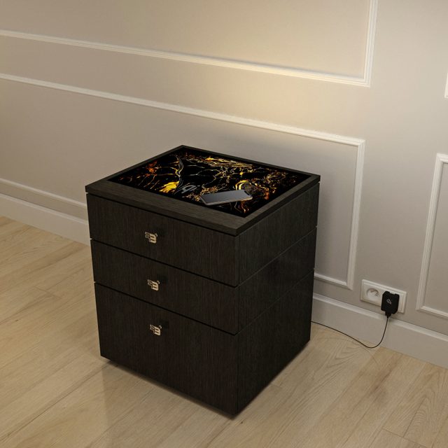 Dark wood three-drawer nightstand with a black and gold illuminated glass top.